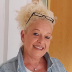 Smiling woman with glasses.